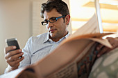 Man using cell phone and reading