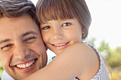 Father holding daughter outdoors