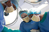 Surgeons bent over patient
