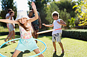 Children hula hooping in backyard