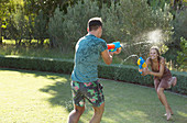 Couple playing with water guns