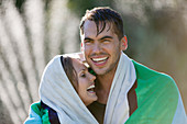 Couple wrapped in towel outdoors