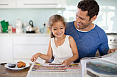 Father and daughter reading newspaper
