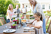 Family setting table outdoors