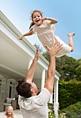 Father and daughter playing outside house