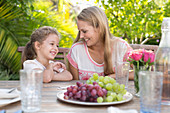 Mother and daughter smiling at table