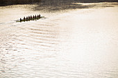 Rowing team in scull on sunny lake