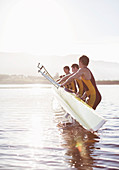 Rowing team placing boat in lake