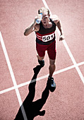 Runner pouring water overhead on track