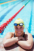 Smiling swimmer leaning at edge of pool