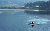 Man rowing scull on lake