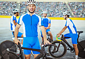 Track cyclists standing in velodrome