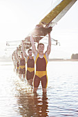 Rowing team carrying scull overhead