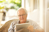Senior man using digital tablet on patio