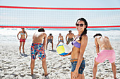 Smiling woman playing beach volleyball