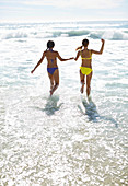 Friends in bikinis holding hands