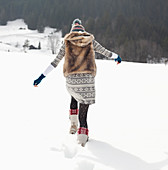 Woman walking in snowy field