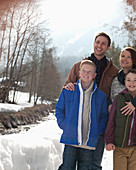 Happy family standing in snow