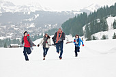 Family running in snowy field