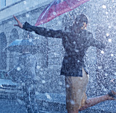 Businesswoman dancing in rain