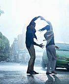 Happy couple dancing in rain