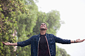 Man with arms outstretched in rain