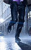 Businessman running in rainy street