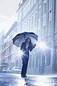 Businesswoman standing under umbrella