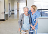 Nurse helping senior patient with walker