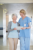 Nurse and aging patient reading chart