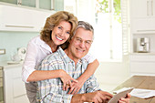 Smiling senior couple with tablet