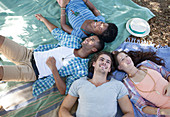 Friends laying on blankets outdoors