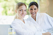 Smiling women in bathrobes at spa