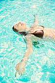 Woman relaxing on back in swimming pool