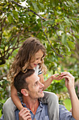 Father carrying daughter on shoulders