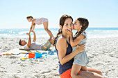 Girl kissing mother's cheek at beach