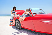 Family packing convertible on beach