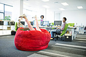 Businesswoman playing in beanbag chair