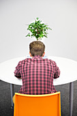 Businessman working at table with plant