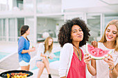 Women eating watermelon at barbecue