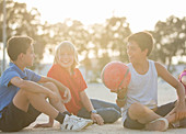 Children sitting with soccer ball