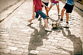 Children playing on cobblestone street
