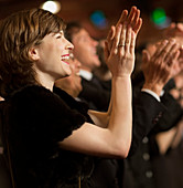 Happy woman clapping in theatre audience