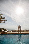 Older couple hugging by pool