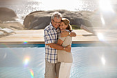 Older couple hugging by pool