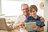 Older man and grandson using tablet