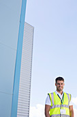 Worker smiling below highrise buildings