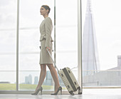 Businesswoman rolling suitcase in airport