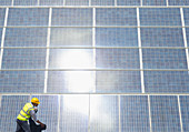 Worker examining solar panels