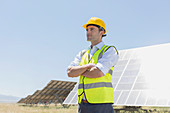 Worker standing by solar panels